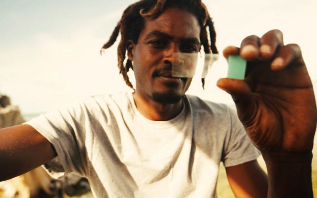 Bahamian fisher observes conch reproductive tissue on a lab slide
