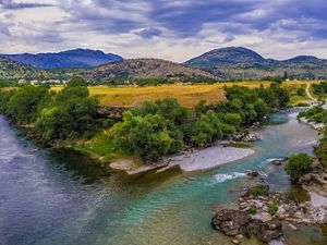 Two rivers meet among hilly terrain and farmland.
