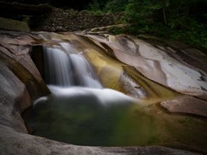 A running stream flows over rocks in Laohegou, Sichuan Province.