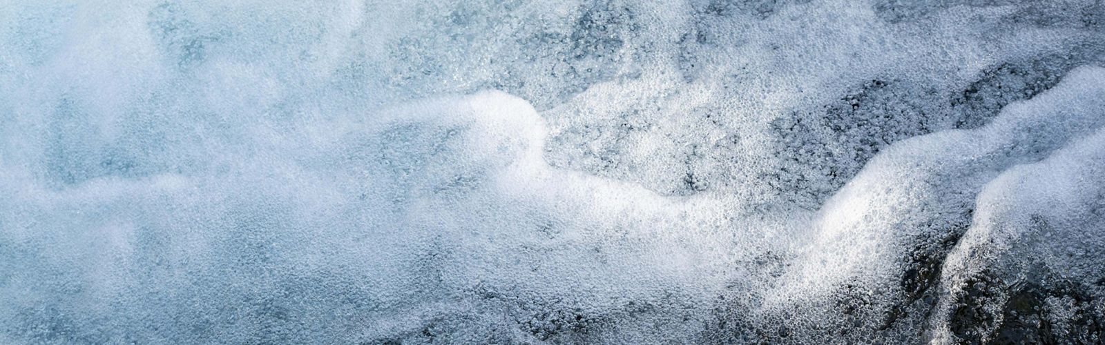 Rushing water foams white as it roars over a series of rapids and falls.