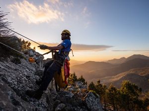 rope technician hanging on cliff 