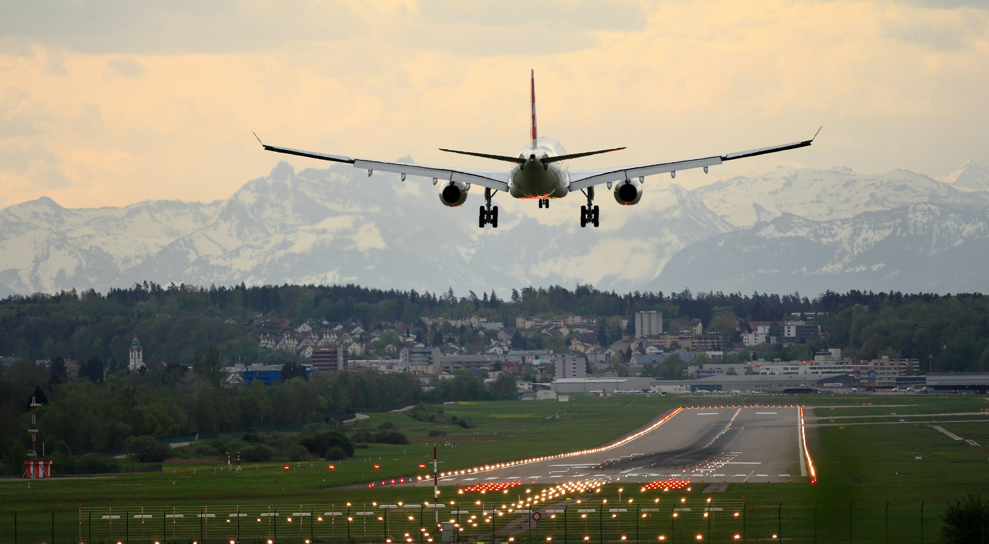 a commercial airline flies through a pink and blue sky