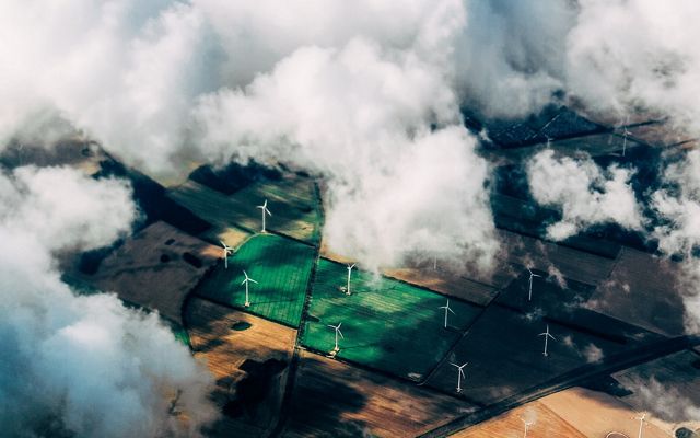 Aerial view of wind turbines on agricultural land.