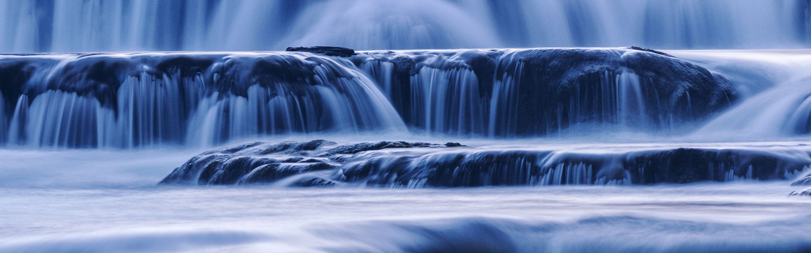 A close-up of water rushing over a short waterfall.